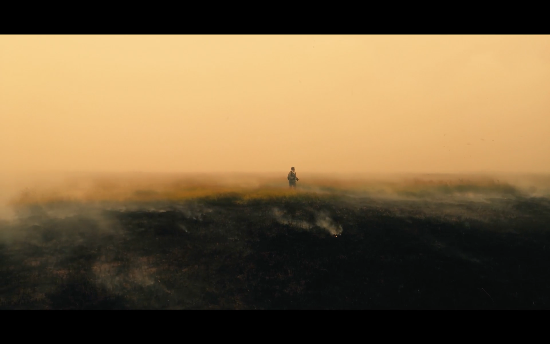 Person i ett landskap omgiven av rök