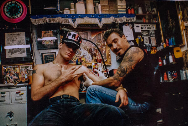 Foto på två personer i en tatureringsstudio.