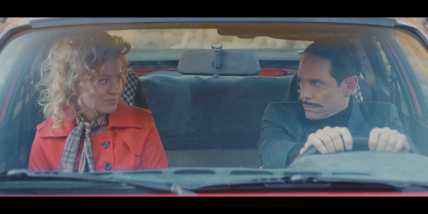 Foto på två personer i en bil som tittar på varandra